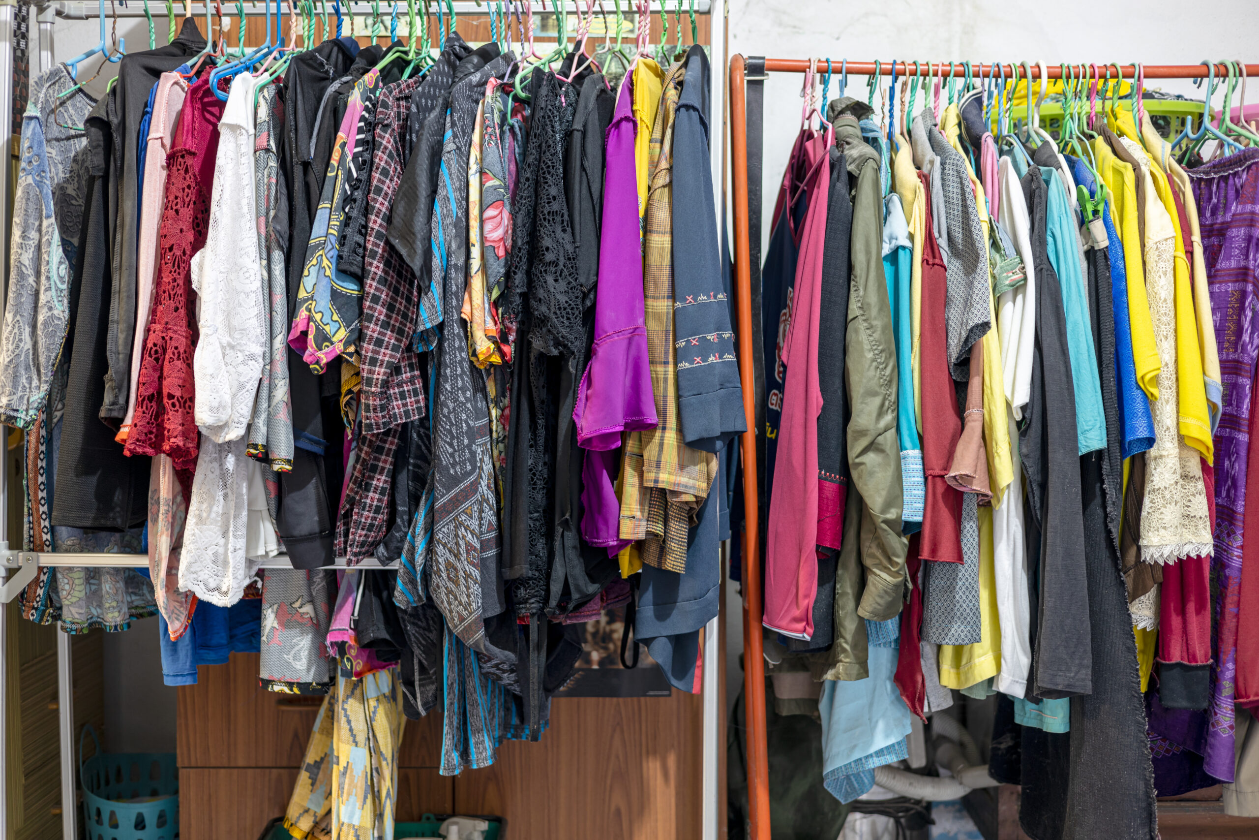 lots of old, colorful clothes hung chaotically on the iron raili