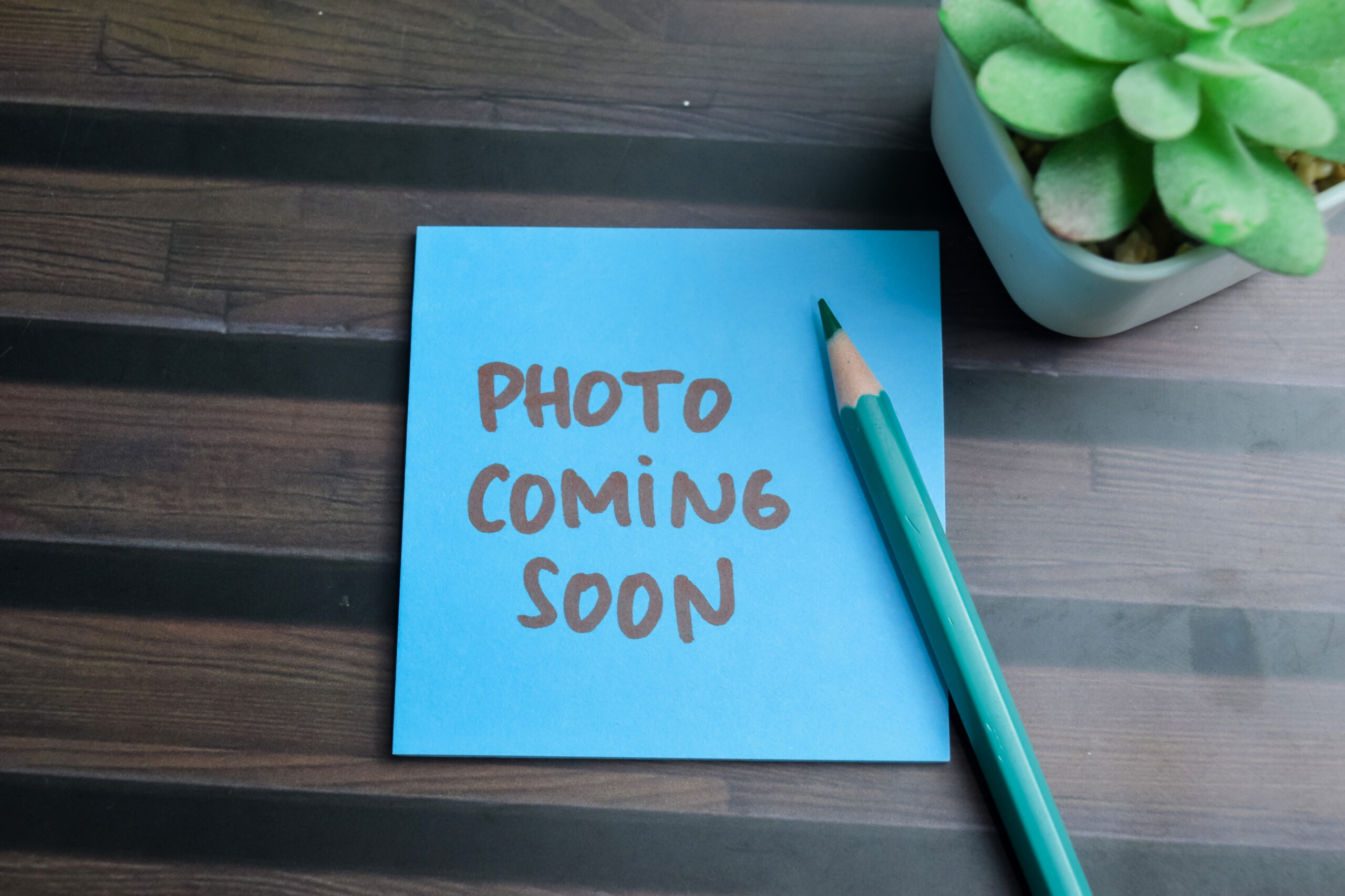 concept of photo coming soon write on sticky notes isolated on wooden table.